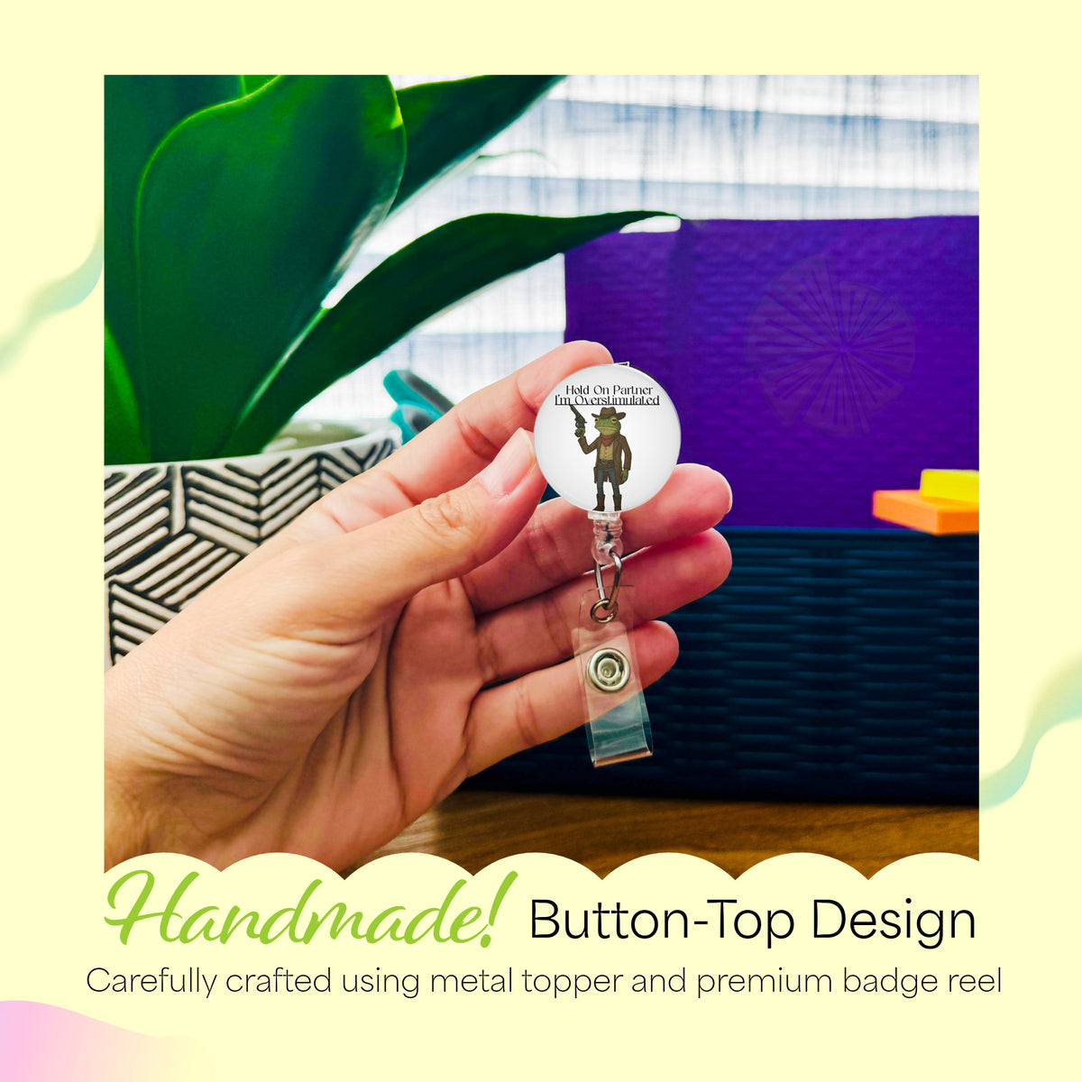Hand holding the Hold On Partner, I'm Overstimulated Frog handmade badge reel