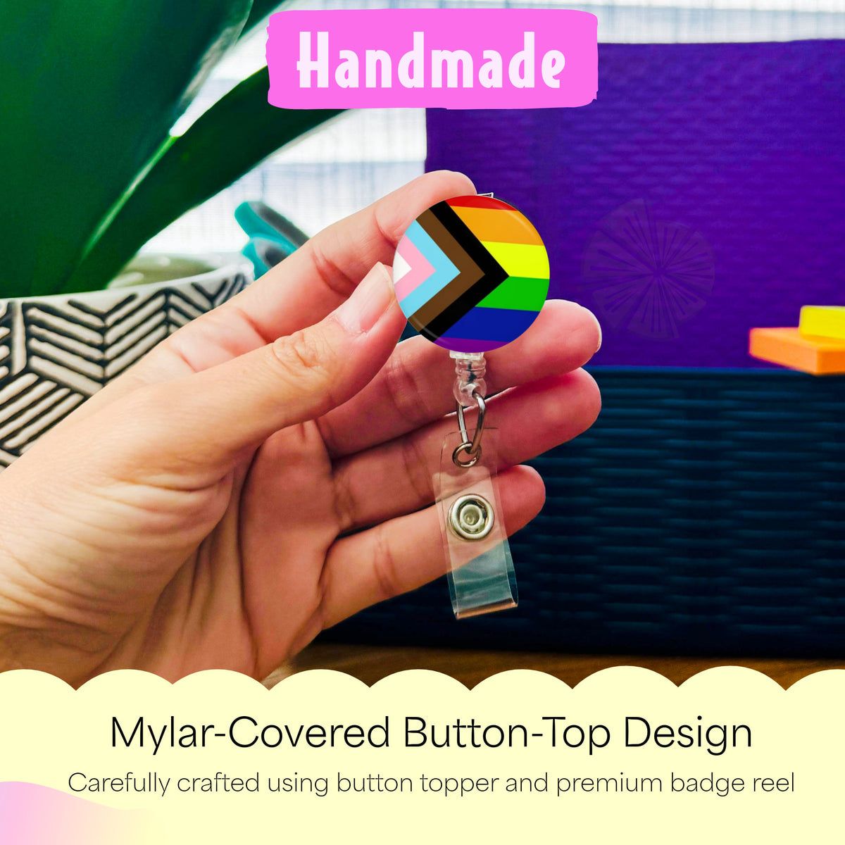 Hand holding the Progress Inclusivity Pride Flag handmade badge reel