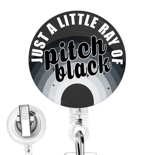 Just a Little Ray of Pitch Black handmade button-top badge reel on a clear retractable reel